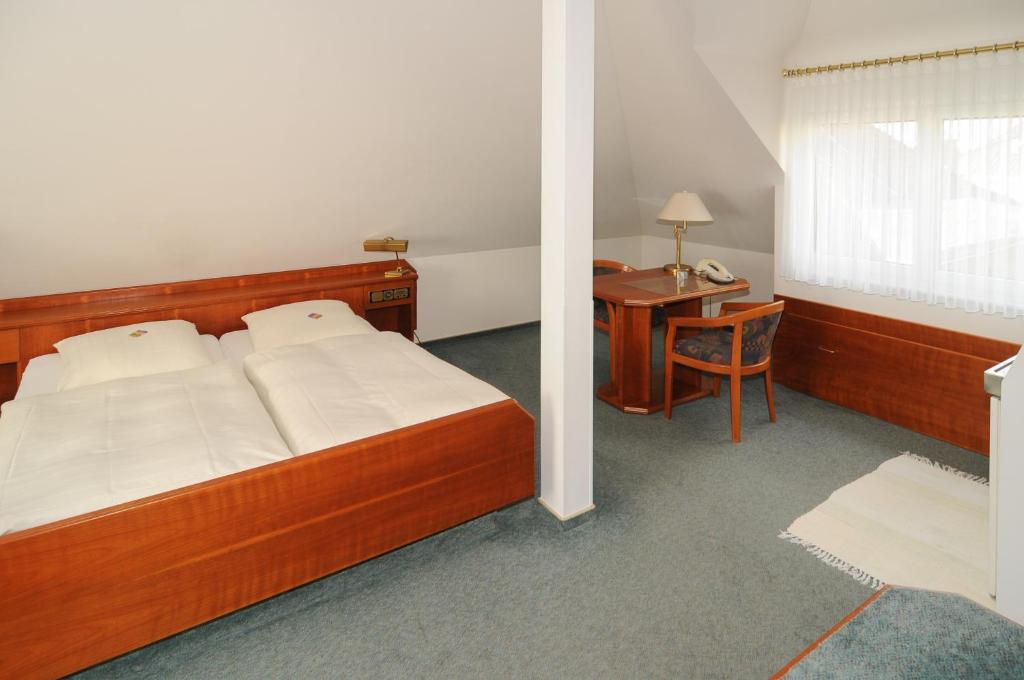 Schlafzimmer mit einem Bett, einem Schreibtisch und einem Tisch in der Unterkunft Alfa Apartment Hotel in Neu Isenburg