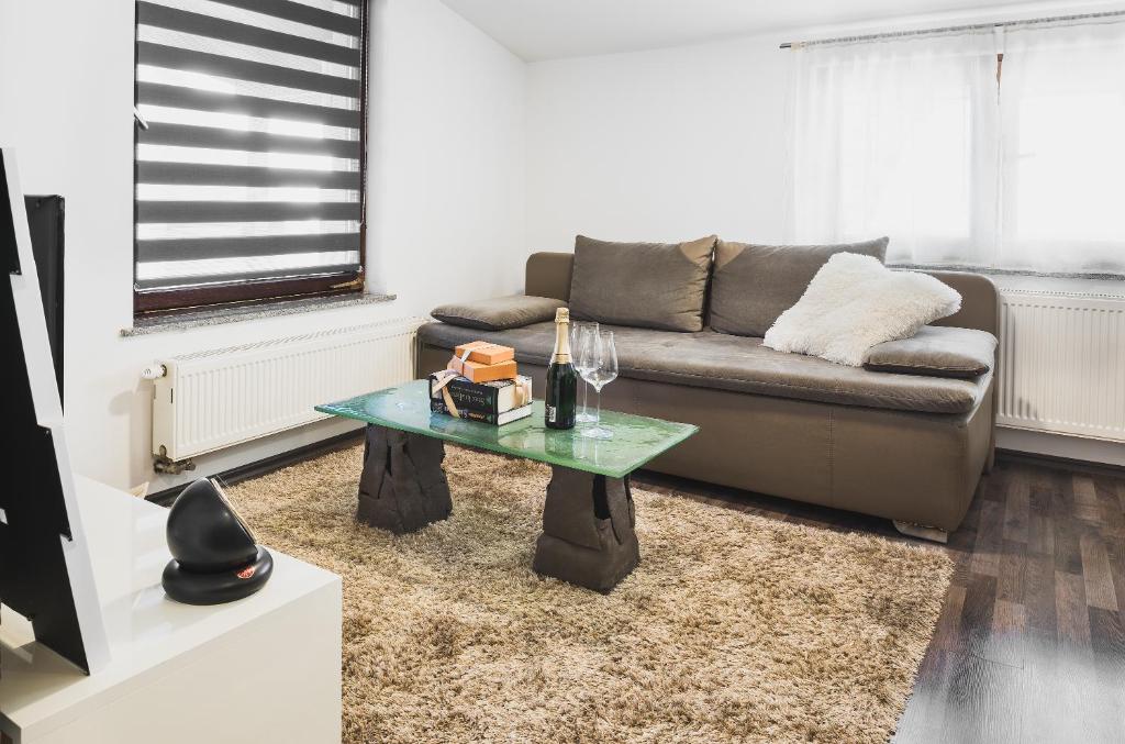 een woonkamer met een bank en een glazen tafel bij Apartments Dijana in Zagreb