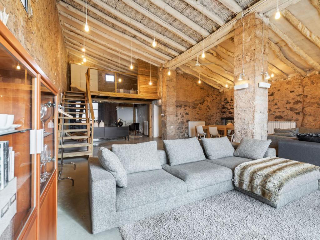 sala de estar con sofá gris y cocina en Belvilla by OYO Cottage Fraga, en Torrente de Cinca