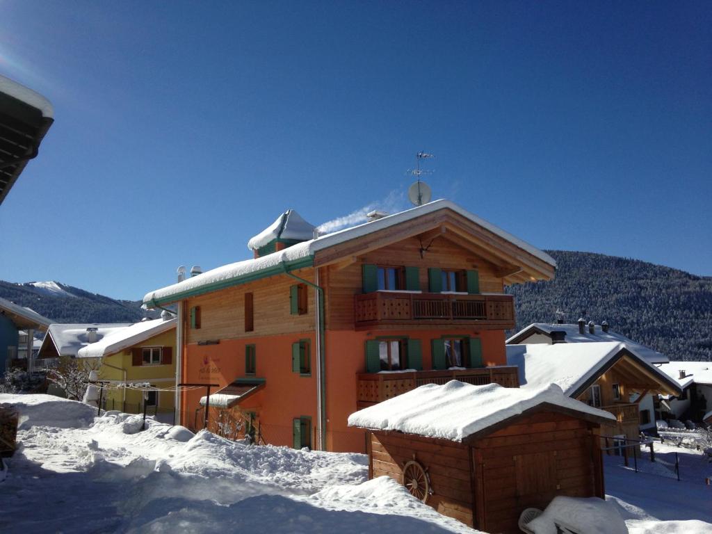 un edificio con nieve en el suelo delante de él en Relais Fior di Bosco, en Folgaria