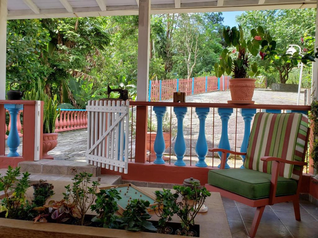 a porch with a chair and potted plants at Nina-Flor Pousada Lumiar in Lumiar