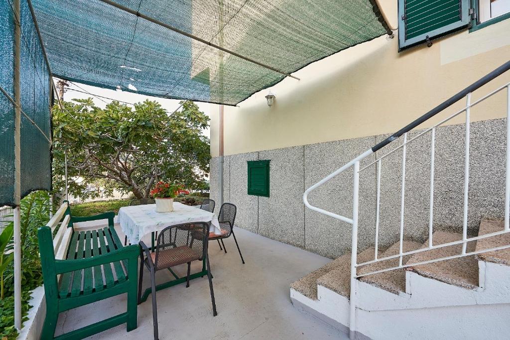 d'une terrasse avec une table, des chaises et des escaliers. dans l'établissement Apartment Ivanka - 200 m from sea, à Trogir