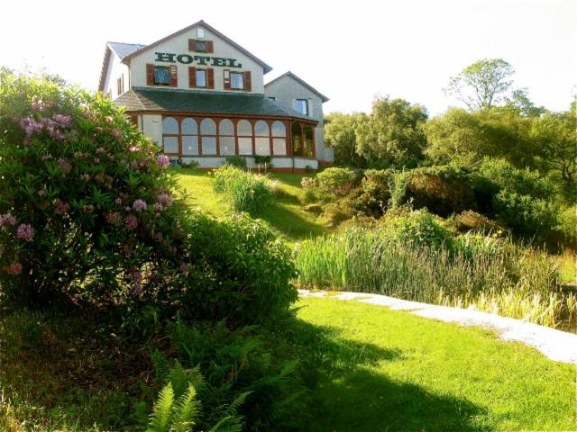 a house sitting on top of a grassy hill at Gairloch Highland Lodge in Gairloch