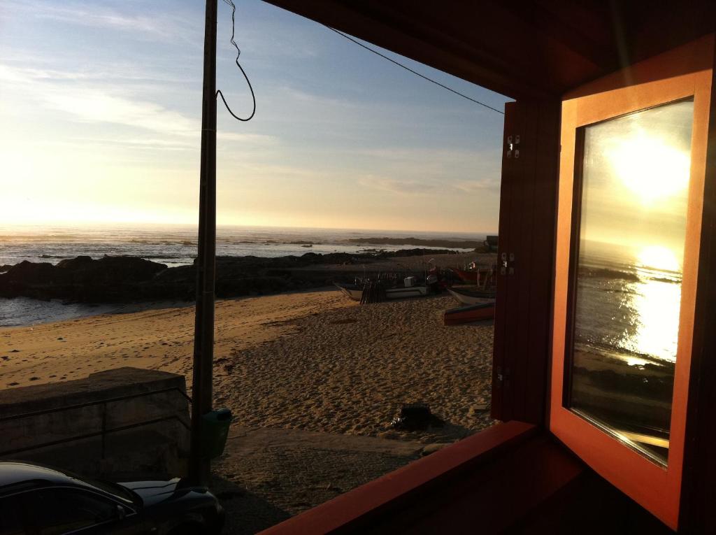 uma vista para a praia a partir da janela de uma casa em Casa do Mar em Vila Chã