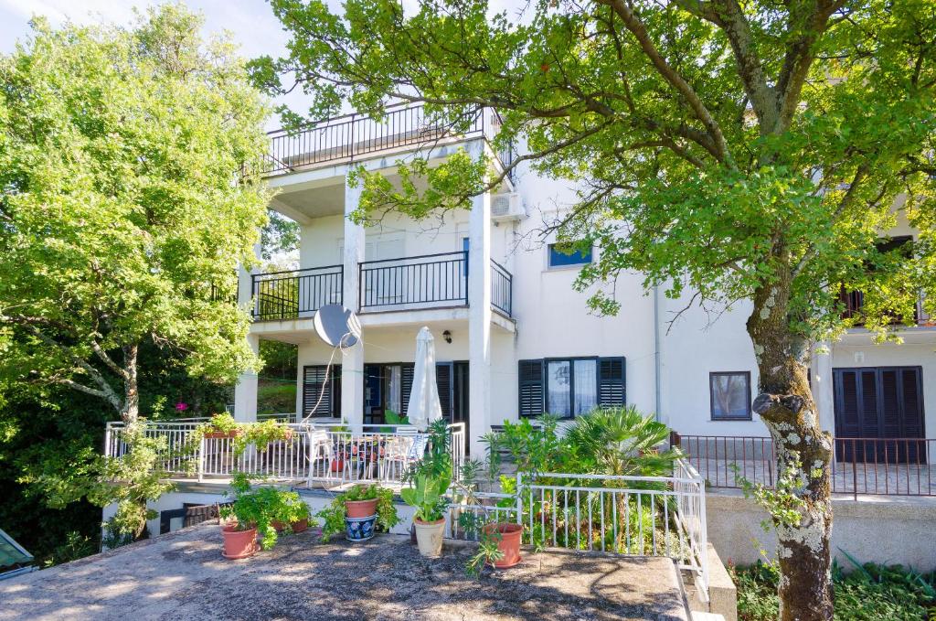 a white house with plants in front of it at Apartments Petra in Crikvenica