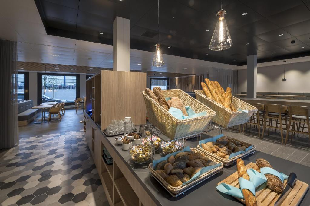 - un buffet avec du pain et des paniers de nourriture sur un comptoir dans l'établissement Holiday Inn Express - Luzern - Kriens, an IHG Hotel, à Lucerne