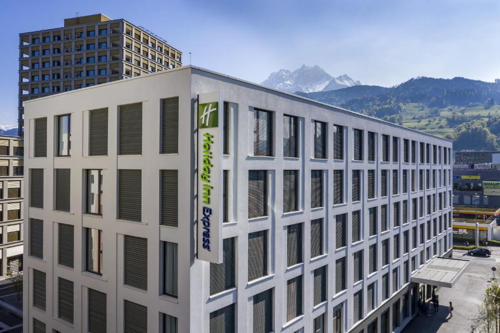 un bâtiment blanc avec une bannière sur son côté dans l'établissement Holiday Inn Express - Luzern - Kriens, an IHG Hotel, à Lucerne