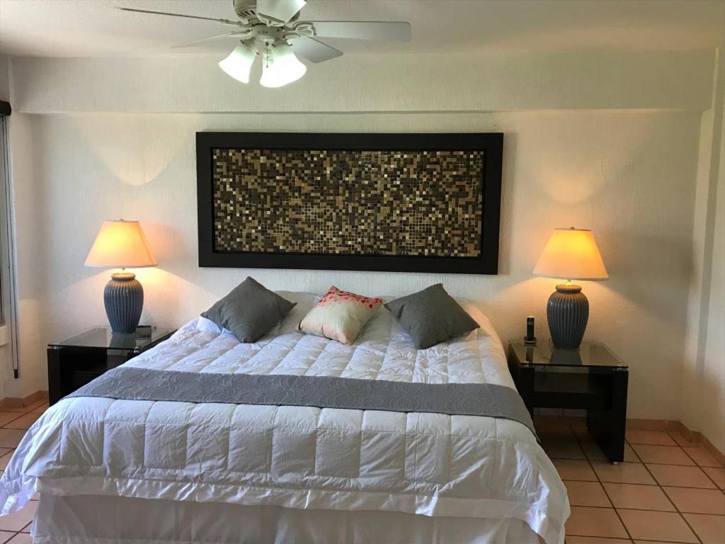 una camera con un letto bianco e 2 lampade di Espaciosa Suite Zona Centro Col El Prado S7 a Casa Blanca La Corregidora