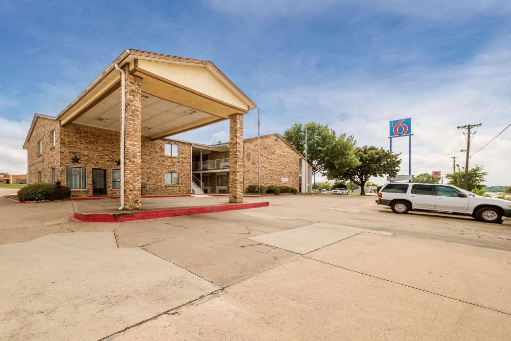 un coche aparcado en un aparcamiento al lado de un edificio en Motel 6-Red Oak, TX - Dallas, en Red Oak