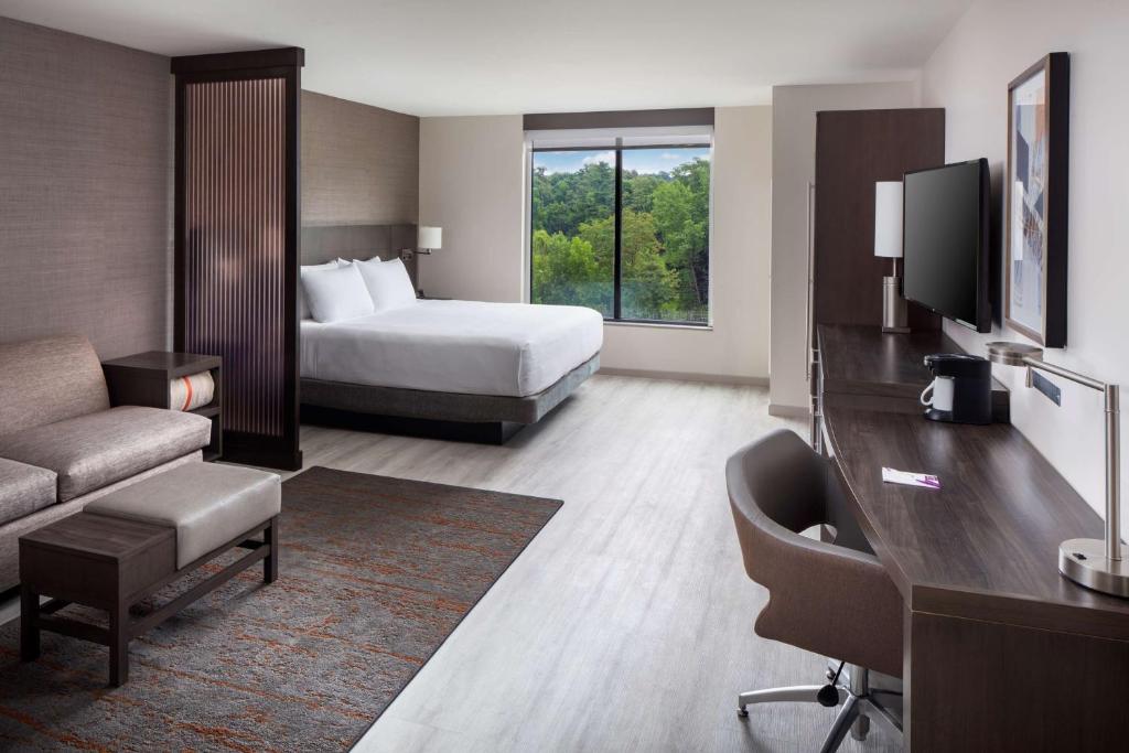 um quarto de hotel com um quarto com uma cama e uma televisão em Hyatt Place Poughkeepsie - Hudson Valley em Poughkeepsie