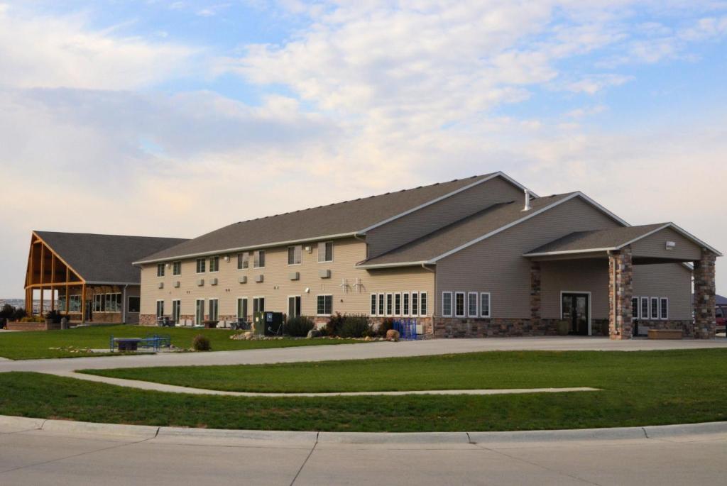 a large white building with a gambrel roof at Cobblestone Inn & Suites - Lake View in Lake View