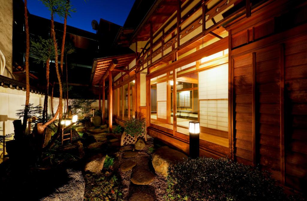 大阪市にある庭之宿 新大阪日本庭園の家 -Residence inn Niwanoyado-の横の灯りを持つ家