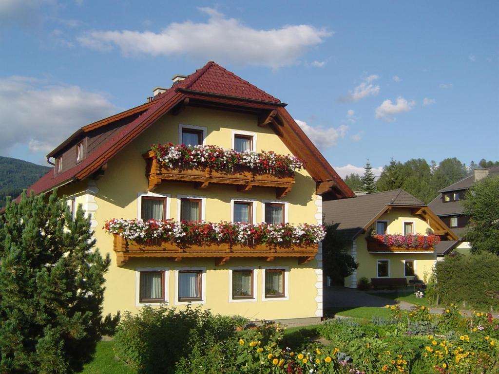 a yellow building with flower boxes on it at Gappmayrhof in Tamsweg