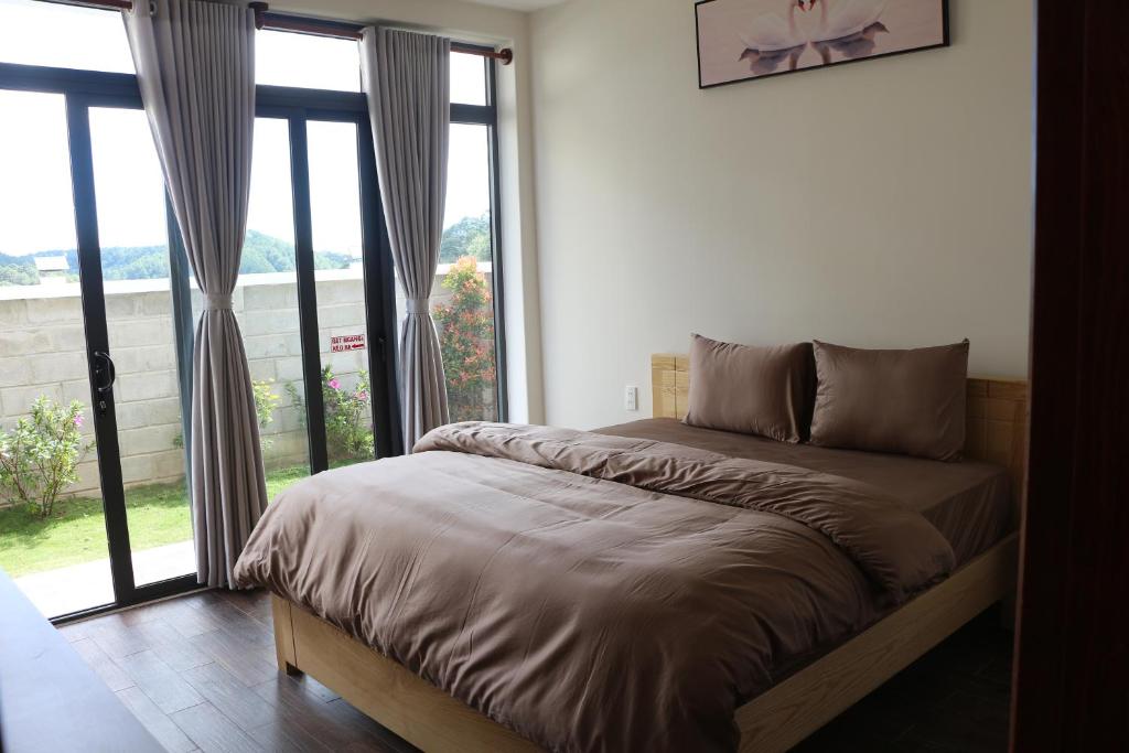 un letto in una camera con una grande finestra di Garden View Villa Đà Lạt - 8 Rooms a Da Lat