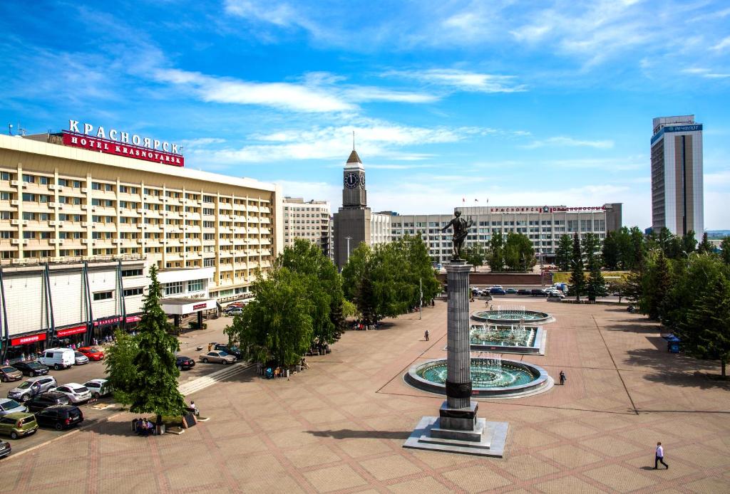 una ciudad con una torre de reloj en medio de una plaza en Hotel Krasnoyarsk, en Krasnoyarsk