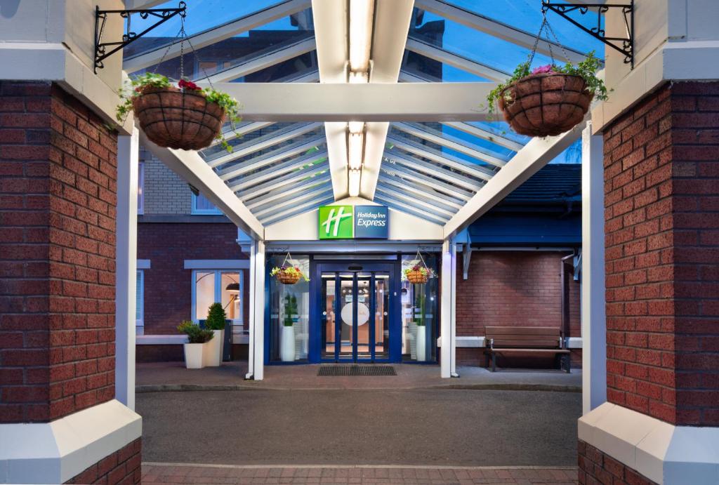 an entrance to a building with two hanging baskets at Holiday Inn Express Strathclyde Park M74, Jct 5, an IHG Hotel in Motherwell