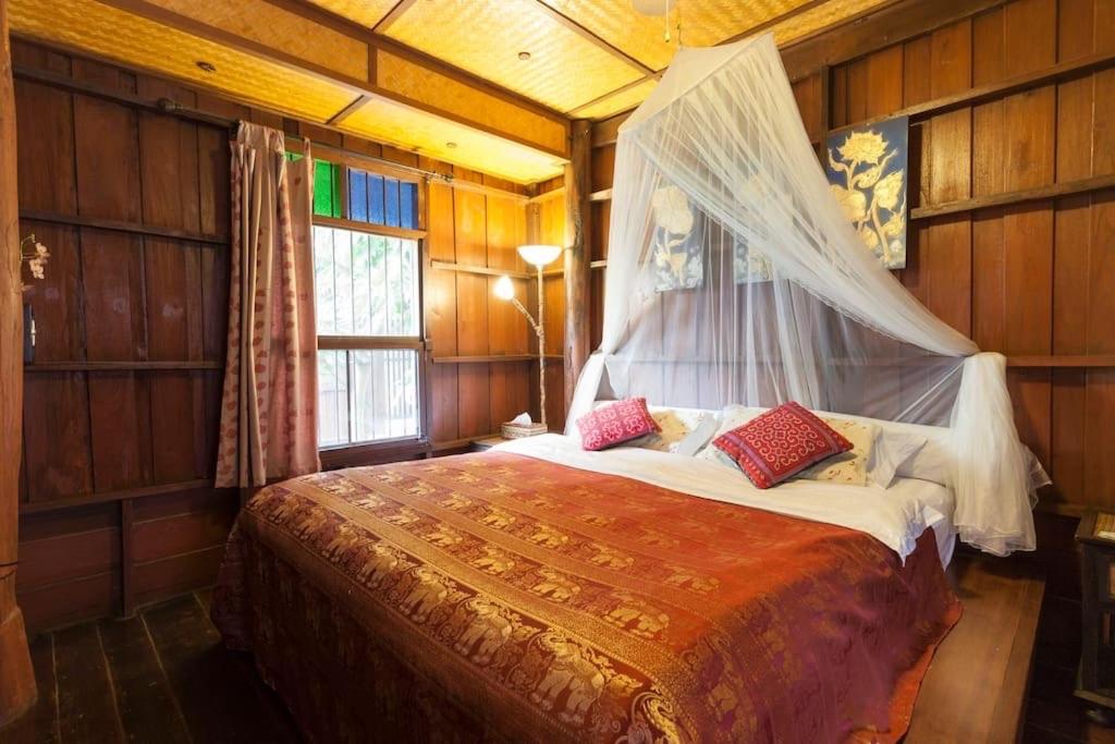 1 dormitorio con 1 cama con mosquitera en Chiang Mai Summer Resort en Chiang Mai