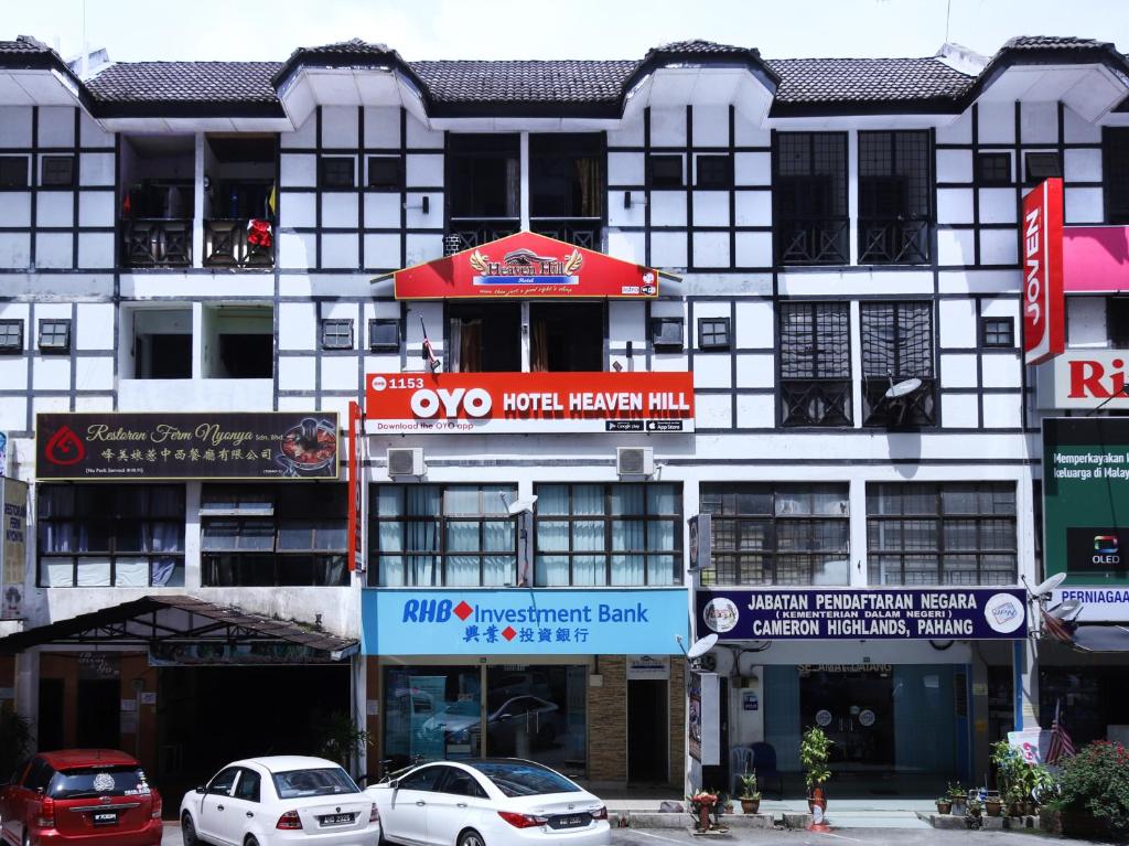 a large white building with cars parked in front of it at Super OYO 1153 Heaven Hill Hotel 1 in Cameron Highlands