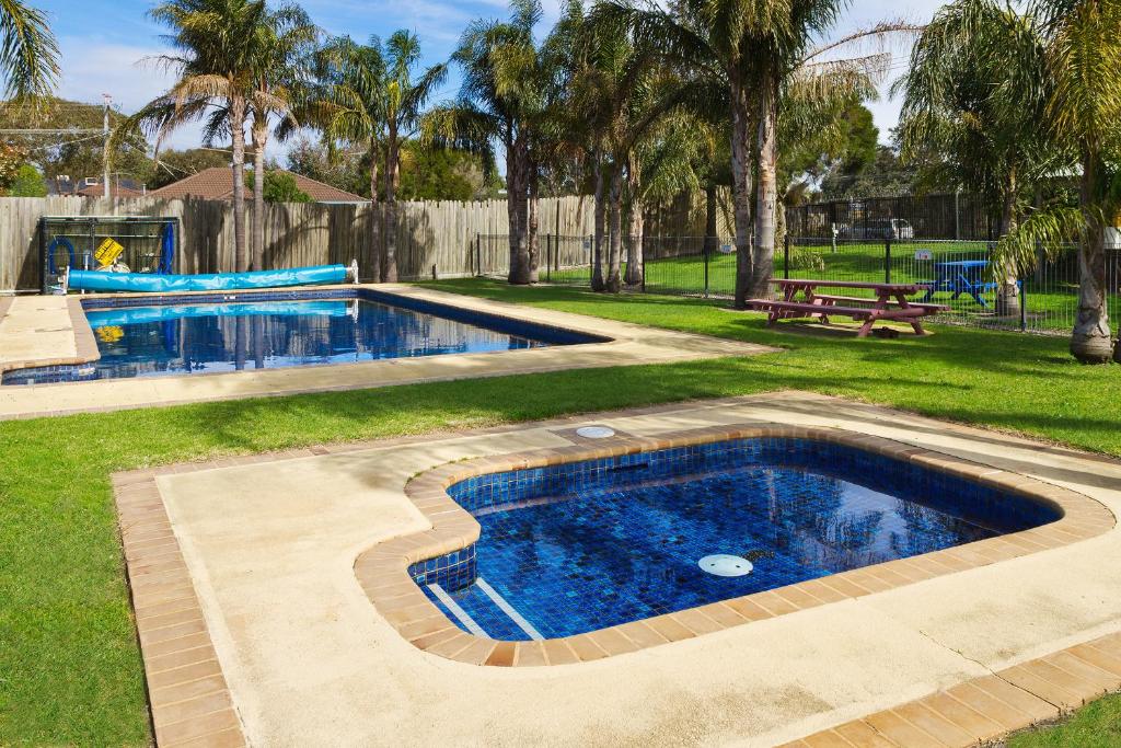 uma piscina num quintal com parque infantil em Carrum Downs Motel em Carrum Downs