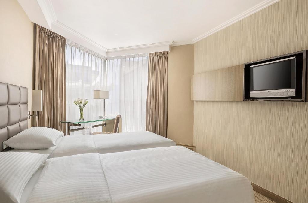 Rúm í herbergi á The Kowloon Hotel