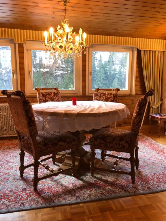 ein Esszimmer mit einem Tisch mit Stühlen und einem Kronleuchter in der Unterkunft Apartment Morris in Bad Gastein