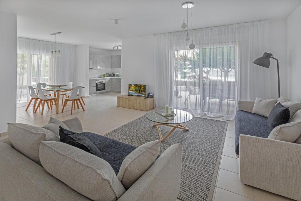 a living room with a couch and a table at Elysia Park in Paphos