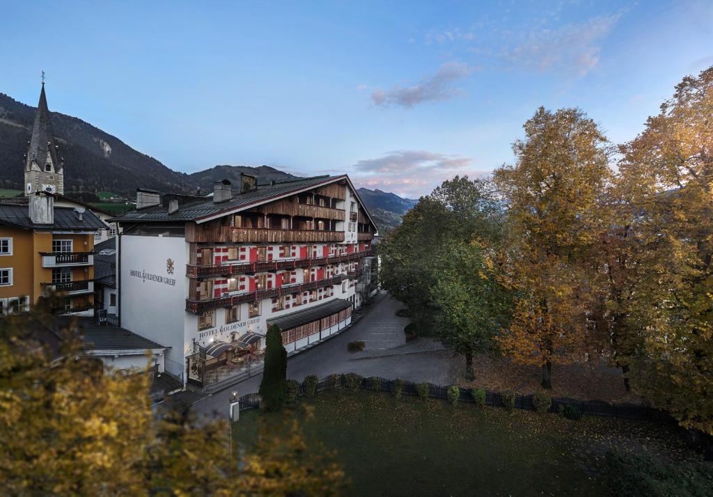 arial view of a building in a town with trees at Hotel Goldener Greif in Kitzbühel