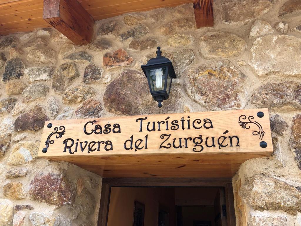 un panneau sur le côté d'un bâtiment en pierre dans l'établissement Casa Turistica Rivera Del Zurguen, à Morille
