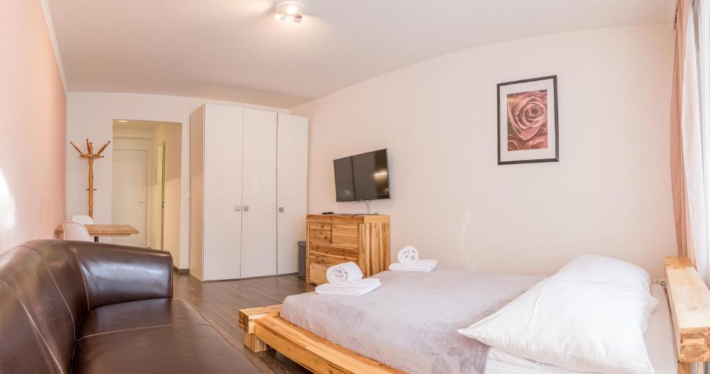 um quarto com uma cama, um sofá e uma televisão em Irmella 9 by Arosa Holiday em Arosa