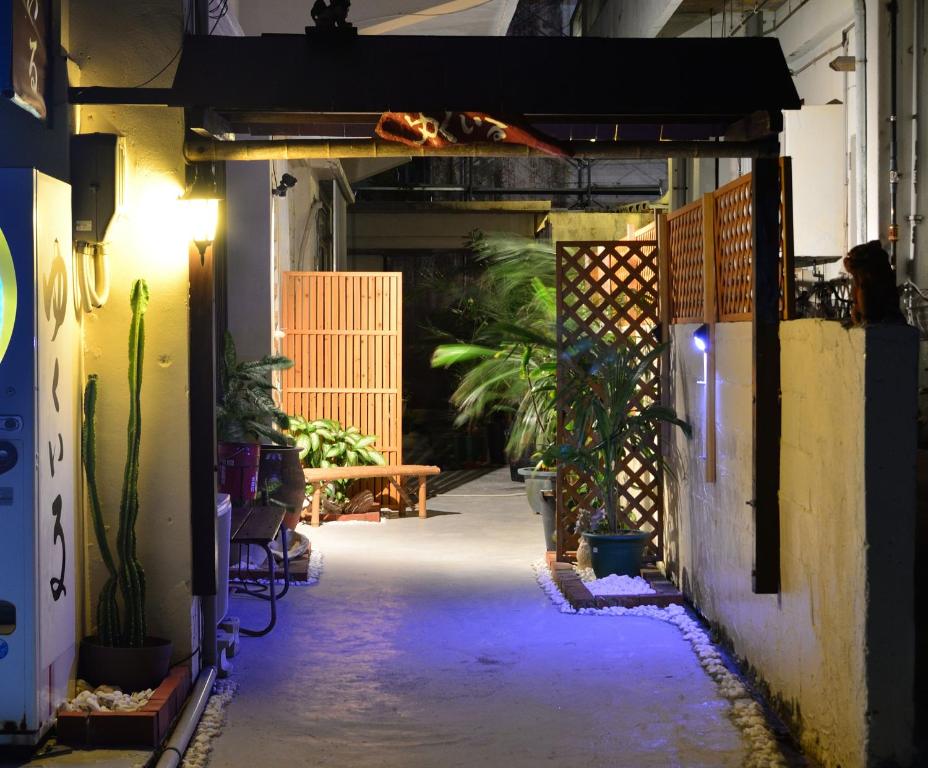 un callejón oscuro con plantas y un banco en un edificio en Accommodation Limited to One Group Per Day Yukuiru, en Isla Miyako