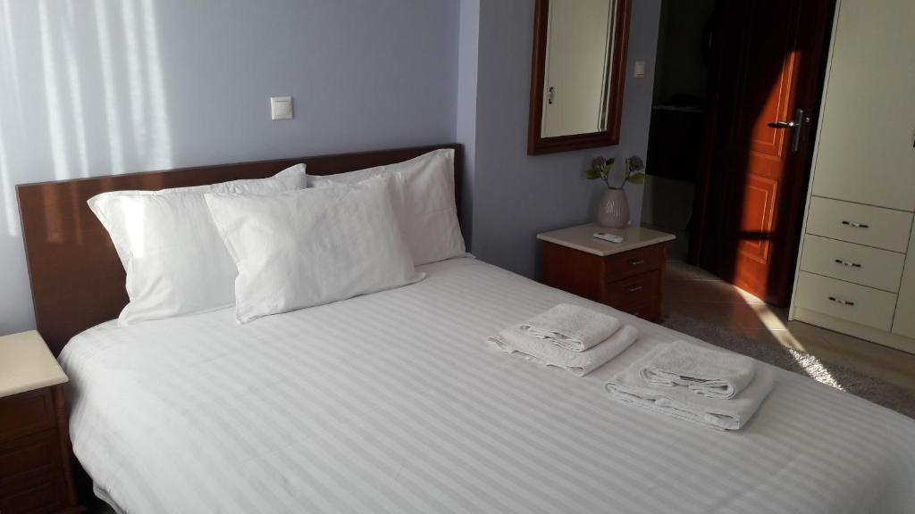 ein Schlafzimmer mit einem Bett mit zwei Handtüchern darauf in der Unterkunft Family apartments in Mesolongi