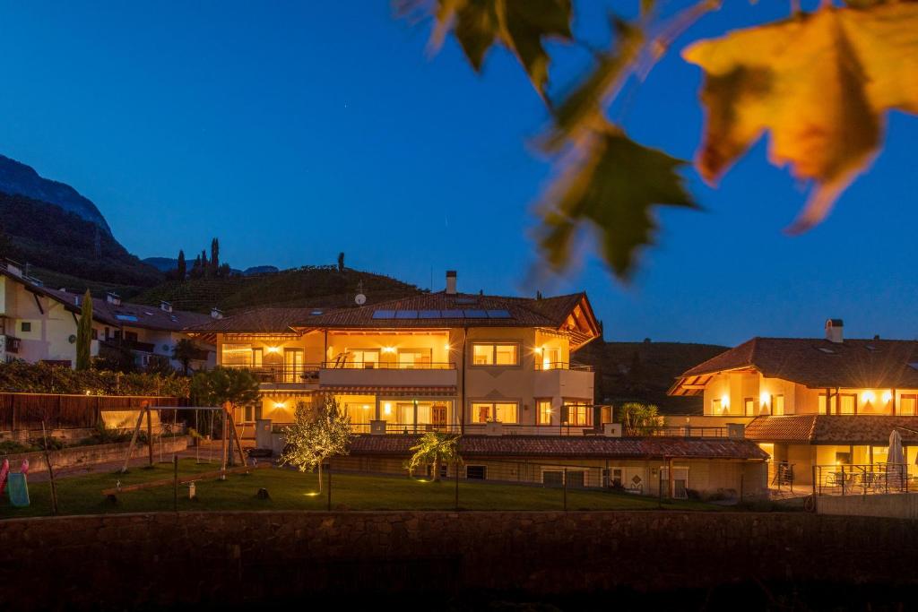 een groot huis met 's nachts verlichting bij Angerhof in Caldaro