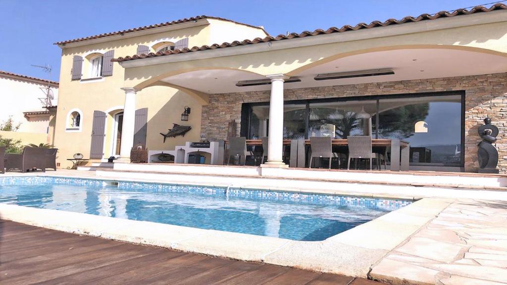 una casa con piscina frente a una casa en Les Geais, en Sainte-Maxime