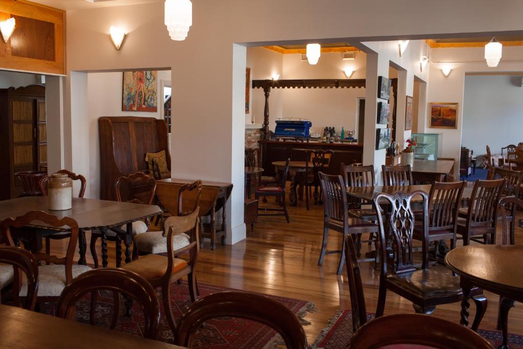 a restaurant with tables and chairs and a bar at Northern Arts Hotel in Castlemaine