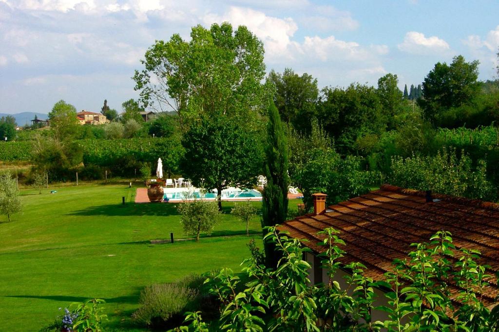 Agriturismo Il Sole Verde في Bucine: ساحة خضراء بها مسبح و منزل