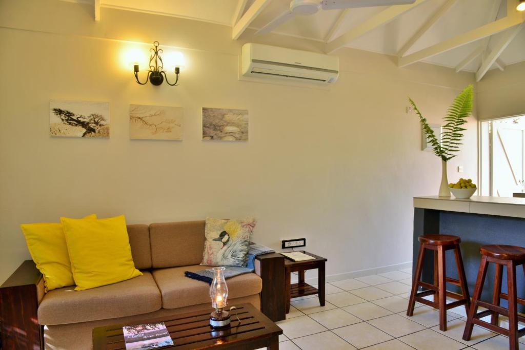 a living room with a couch and a table at Chobe River Cottages in Kasane