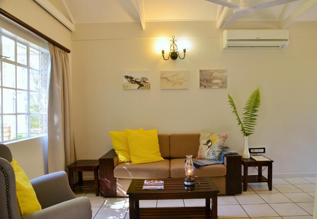 a living room with a couch and a table at Chobe River Cottages in Kasane