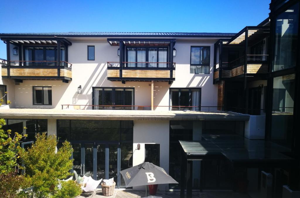 an apartment building with an umbrella in front of it at Asilia Suites Knysna Waterfront in Knysna