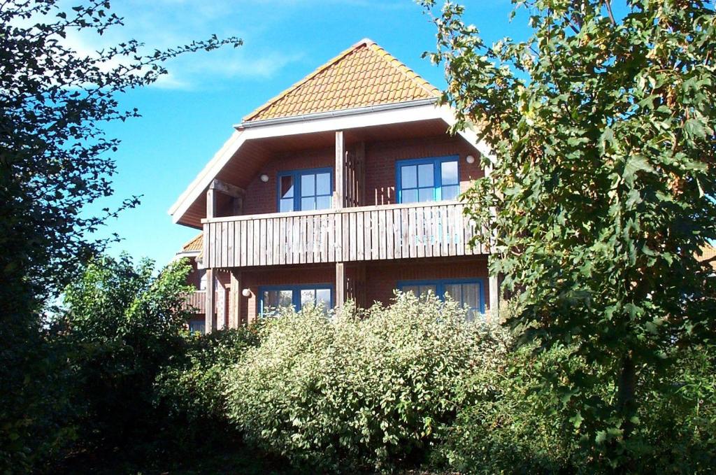 a large house with a balcony on the side of it at LHMW12102-FeWo-an-de-Moehl in Lemkenhafen auf Fehmarn