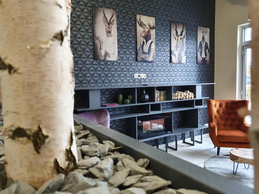 a living room with a fireplace and a tree at Hotel LifeStyle Mindelheim in Mindelheim