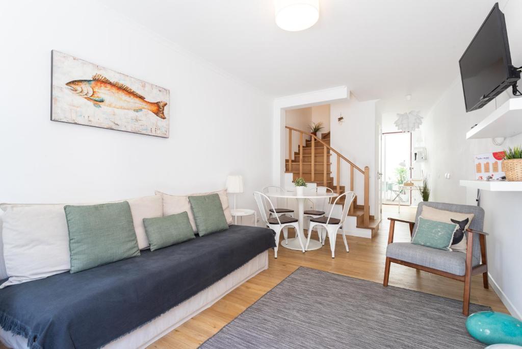 un soggiorno con un divano e un tavolo di FLH Ericeira Cozy House with Terrace a Ericeira