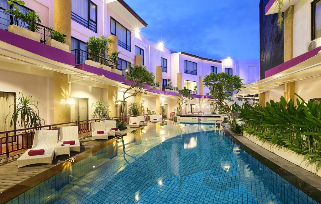 a swimming pool in the middle of a building at Kuta Central Park Hotel in Kuta