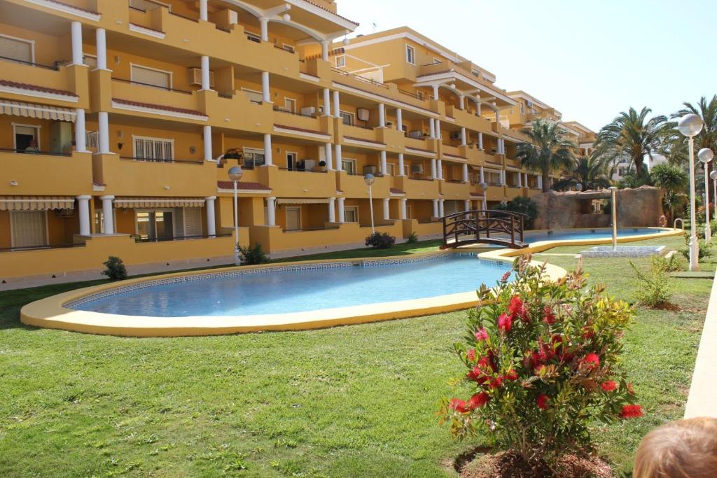 a swimming pool in front of a building at Apartamento Cascadas - Deniasol in Denia