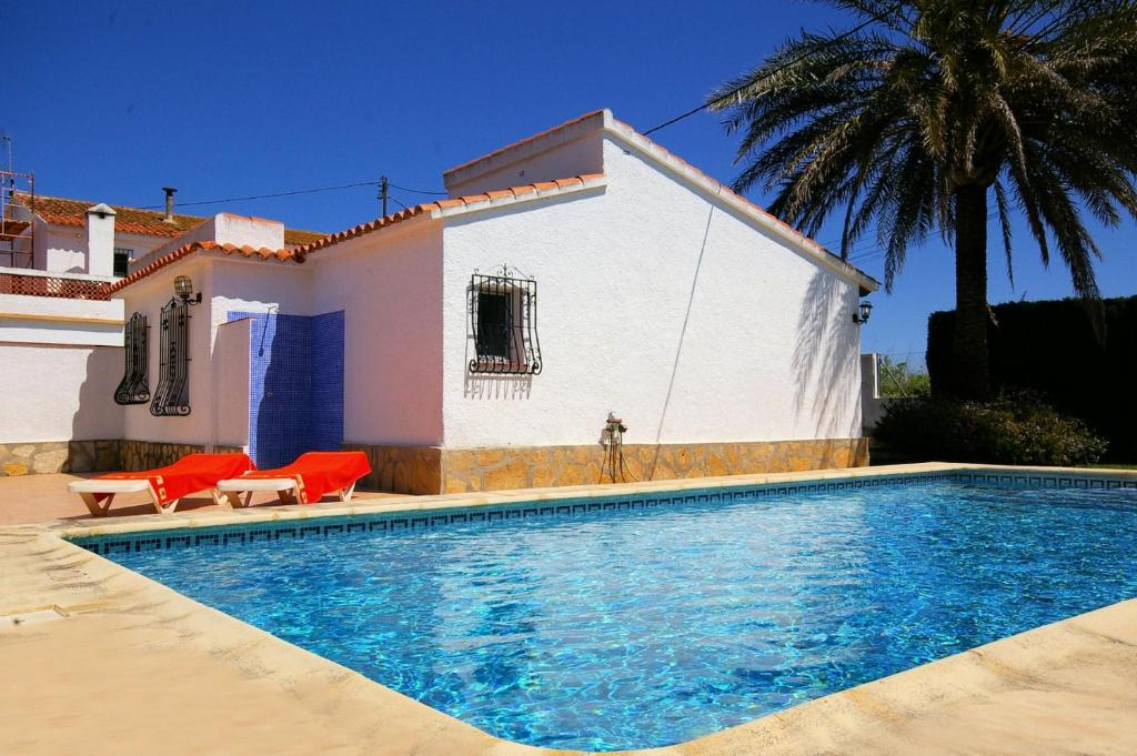 a villa with a swimming pool in front of a house at Villa Azul - Deniasol in Denia