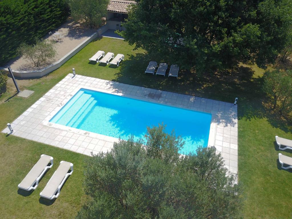 an overhead view of a large swimming pool with lounge chairs at La Bastide au Ventoux in Bédoin