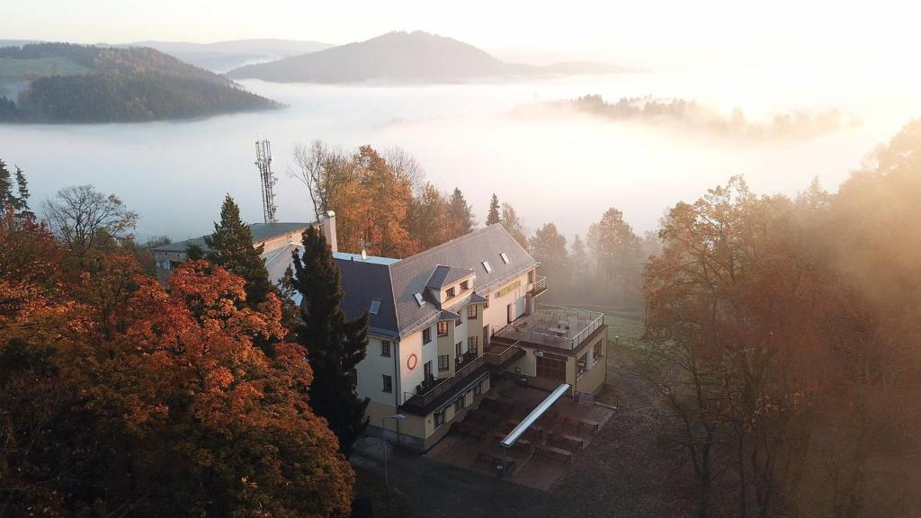 an aerial view of a house in the middle of a lake at Parkhotel Smržovka in Smržovka