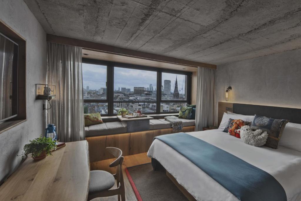 Cette chambre comprend un lit et une grande fenêtre. dans l'établissement Treehouse Hotel London, à Londres