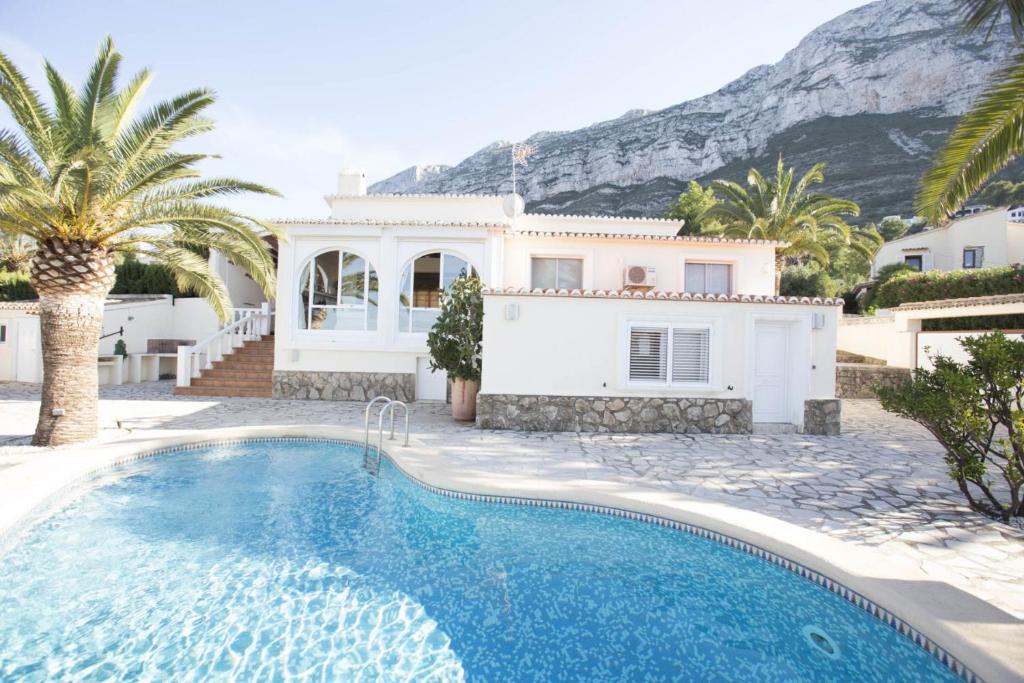 a villa with a swimming pool in front of a house at Villa Pita - Deniasol in Denia