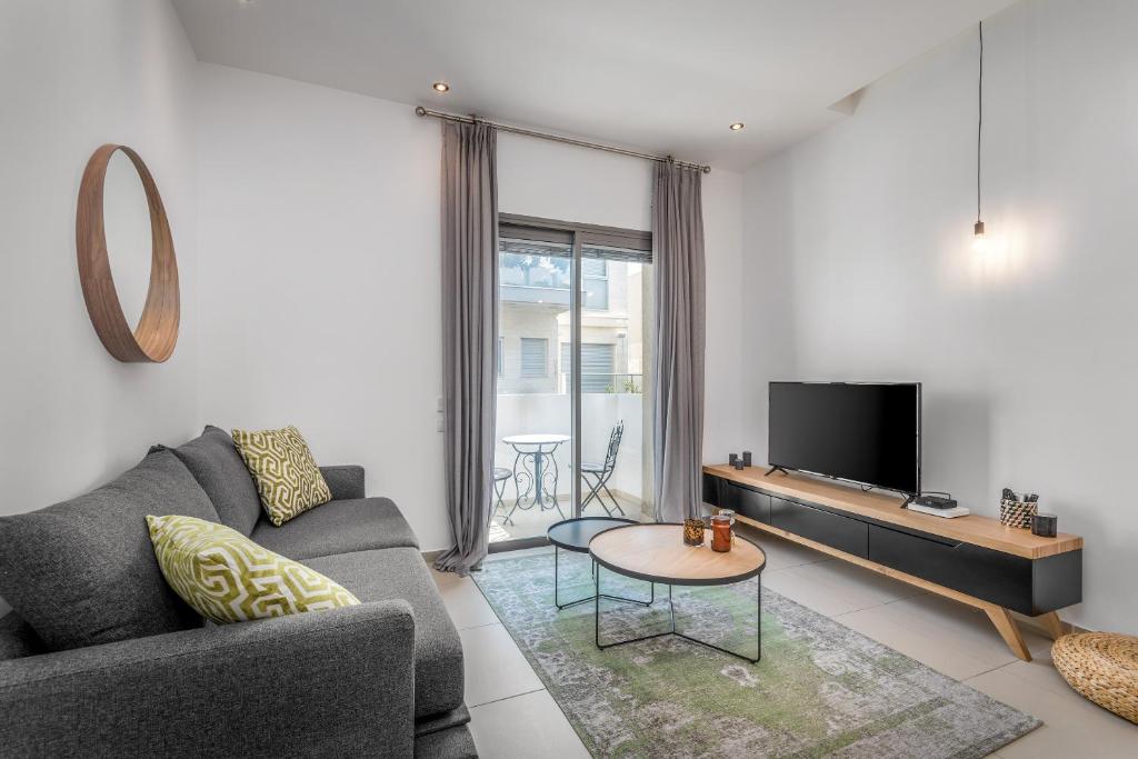- un salon avec un canapé et une télévision dans l'établissement Ben Gurion Area - Modern 2 BDR with balcony, à Tel Aviv