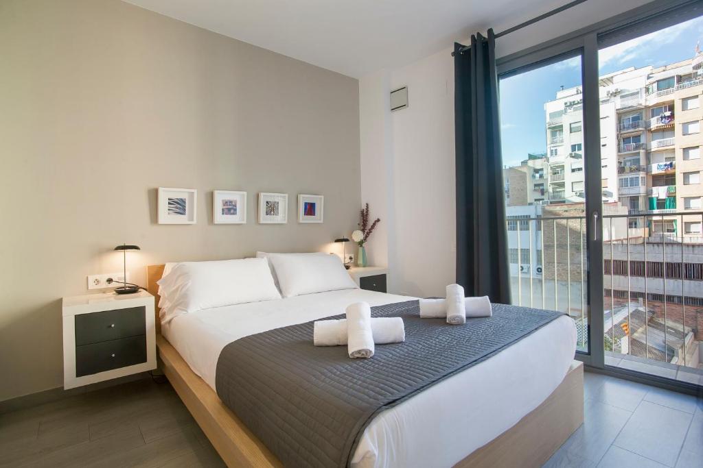 a bedroom with a large bed and a large window at BBarcelona Gaudí Flats in Barcelona